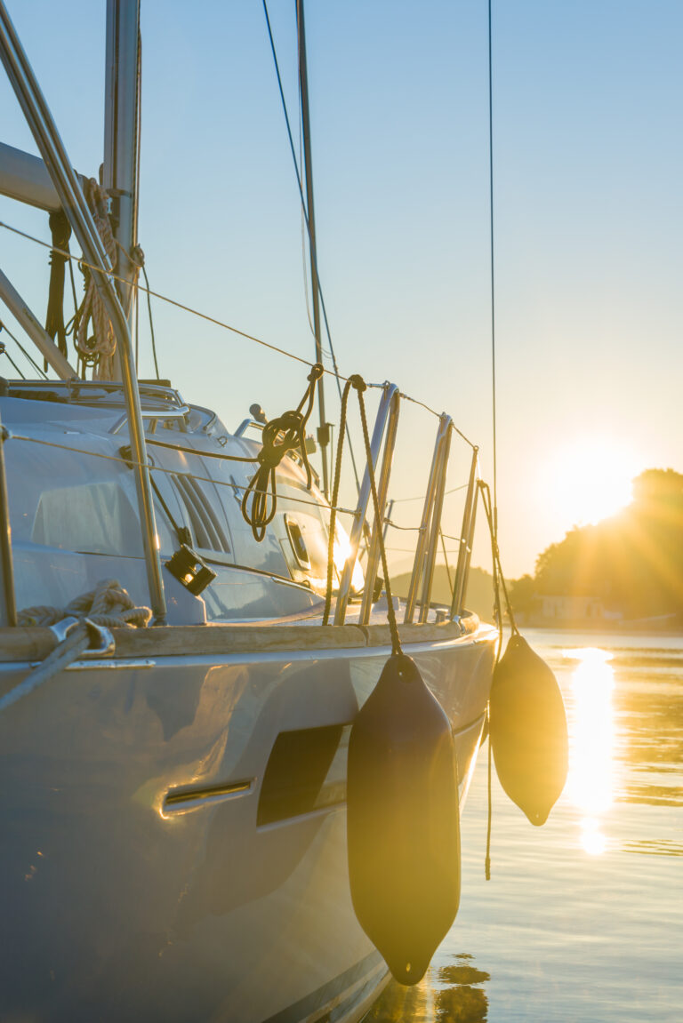 Home sailing yacht boat on on ocean at sunrise