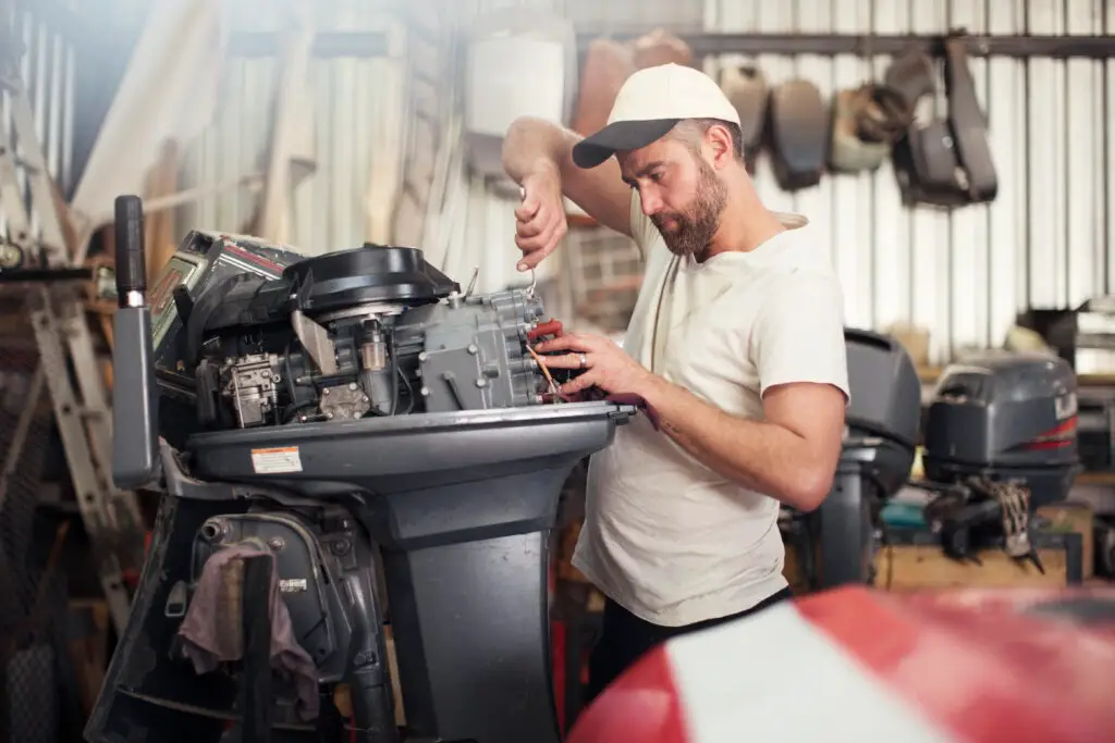 Technician repairing an outboard motor in a marine service shop